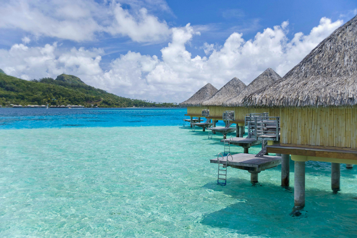 One of the world’s most popular honeymoon destinations, Bora Bora is built for romance. The island’s signature resort hideaways are charming thatched-roof overwater bungalows, where you can listen to the rhythms of the gentle seas beneath you. (Photo Credits: © Helen Havard) 